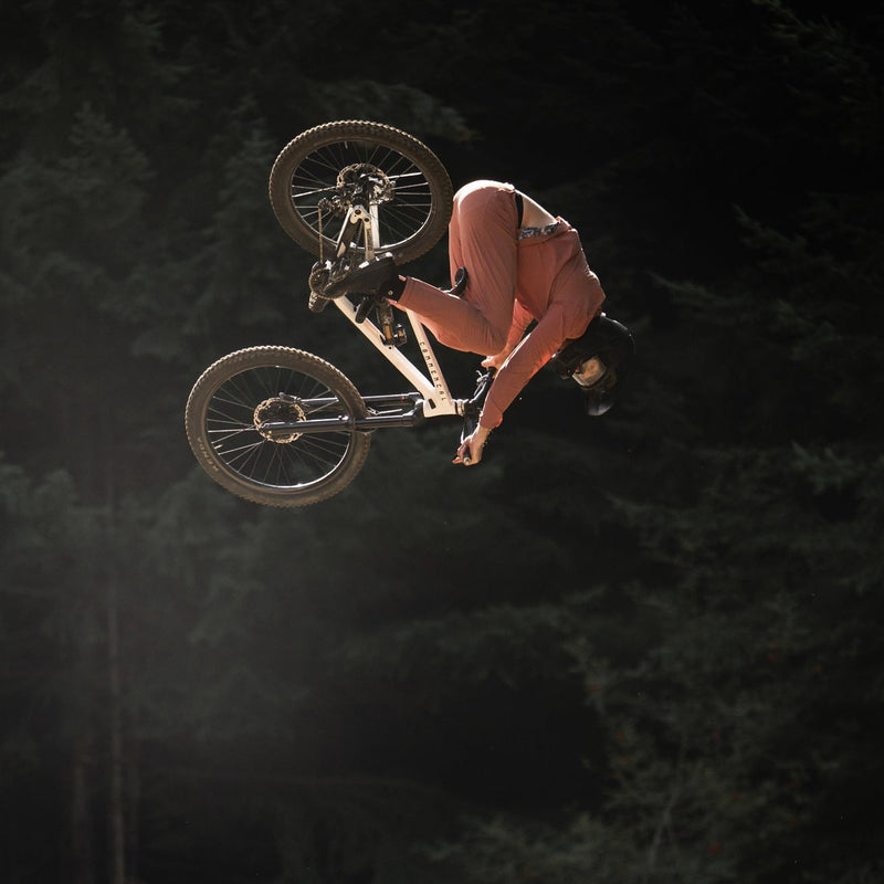 Person on a bicycle performing a jump against a dark background