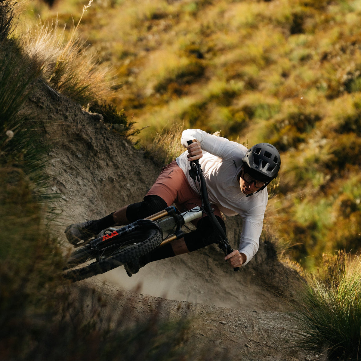 Person riding a mountain bike on a dirt trail with a scenic background