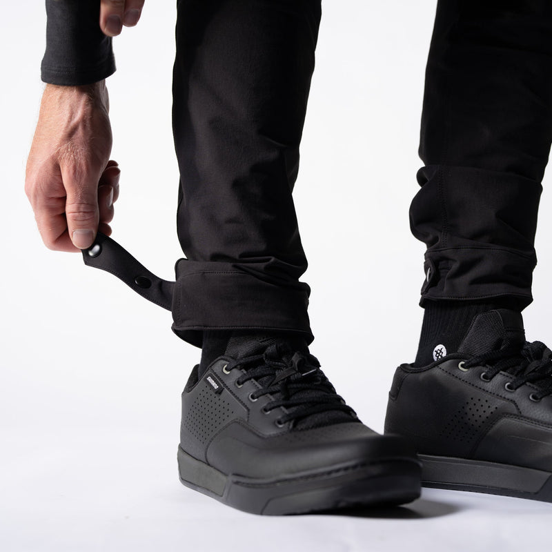 Person wearing black sneakers with a white background