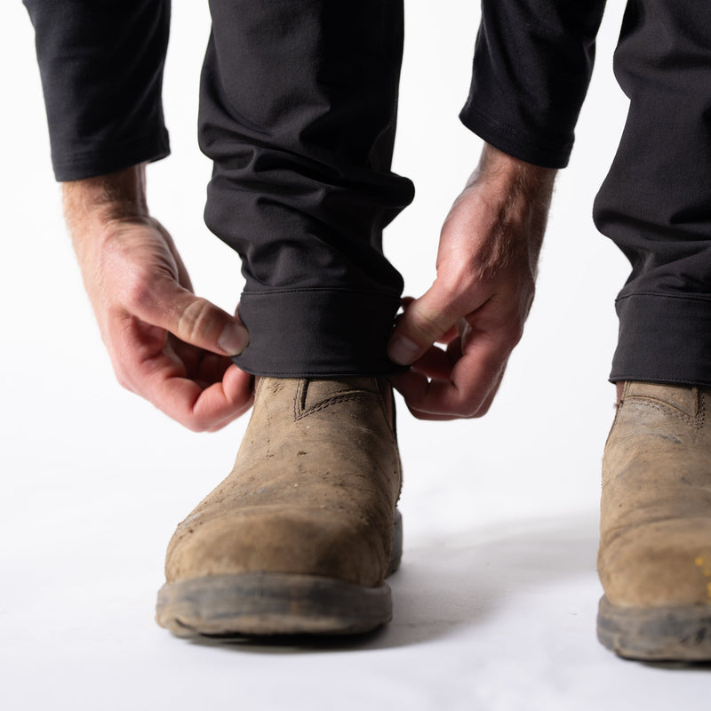 Person wearing dirty work boots on a white background