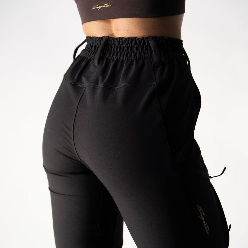 Person wearing black athletic pants and sports bra on a white background