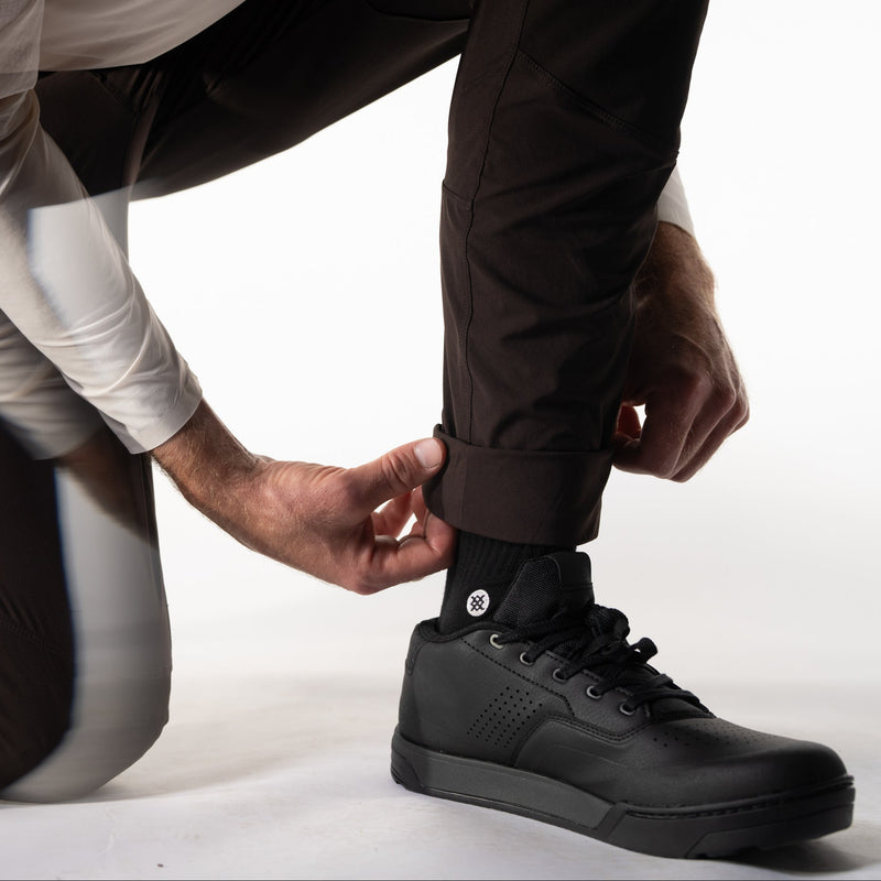 Person wearing black sneakers on a white background