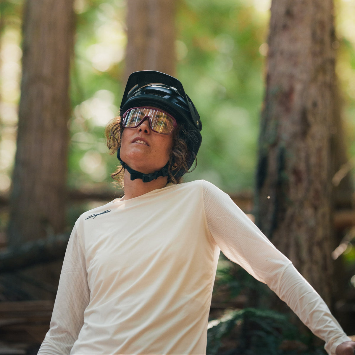 Person wearing a helmet and sunglasses in a forest setting