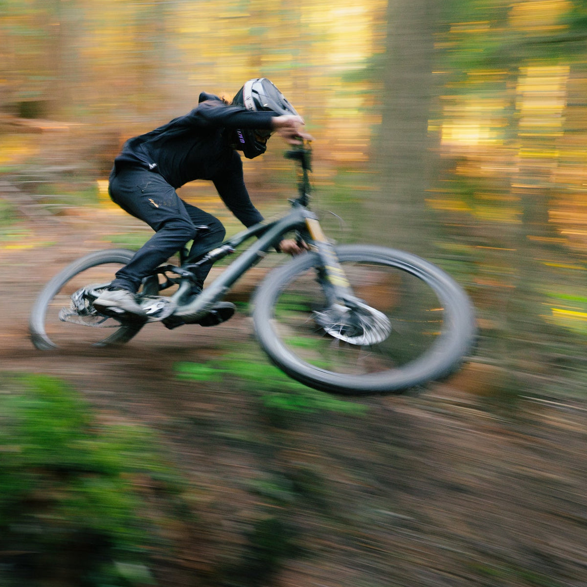 Person riding a mountain bike through a forest